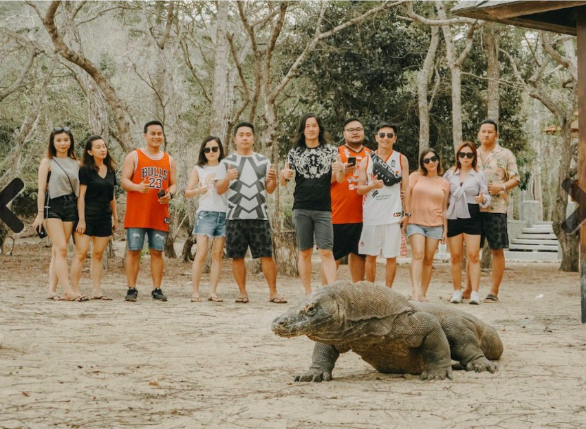 Tourists with a Komodo dragon on Komodo Island